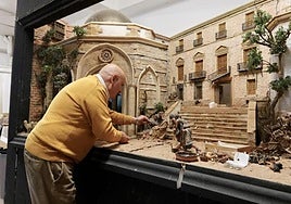 El belenista Pedro Ródenas junto al belén de San Nicolás afectado por la dana.