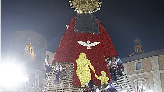La figura de una mujer y un niño bajo una paloma, protagonistas del manto de la Virgen en la Ofrenda