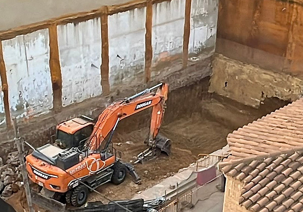 Excavadora trabajando en la obra junto la finca colapsada.