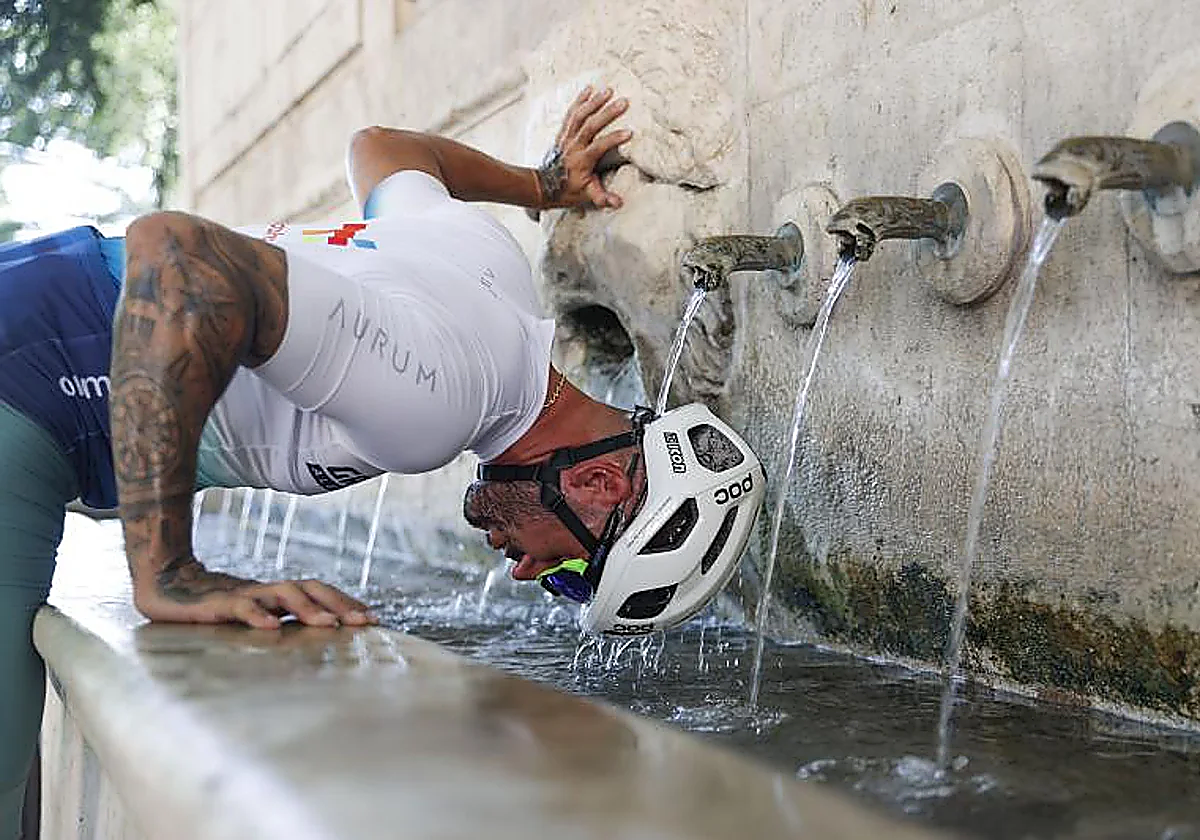 Un ciclista se refresca en una fuente de Xàtiva.