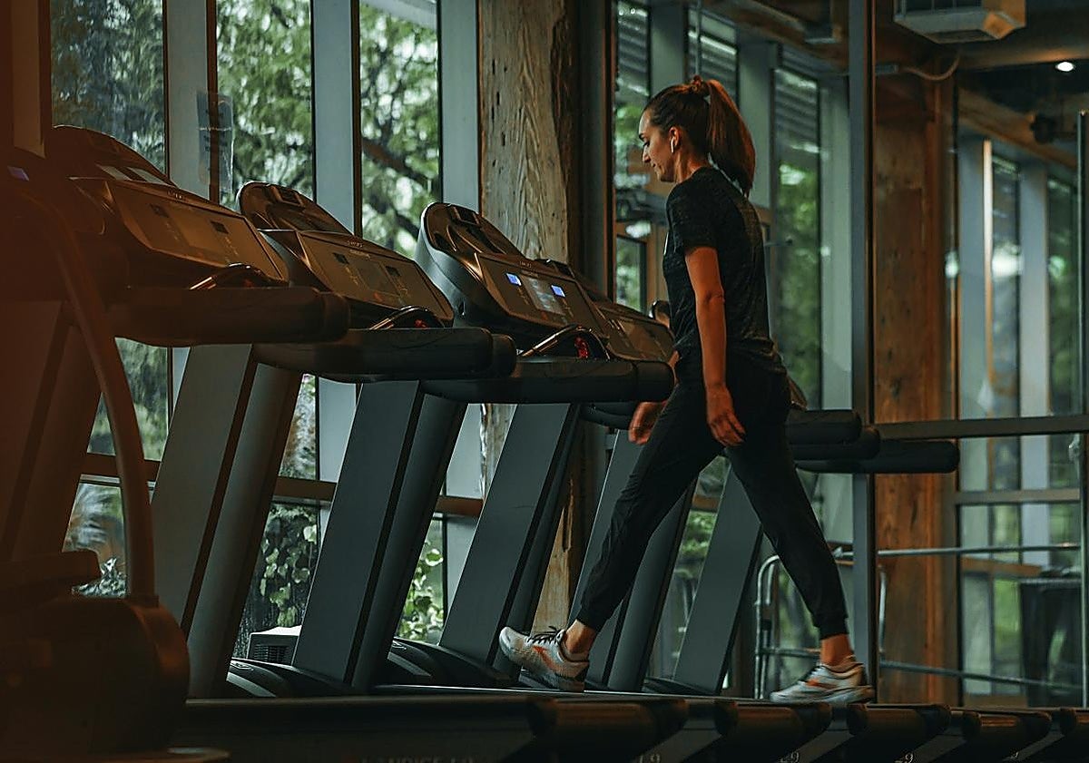 Una mujer entrena cardio en una cinta.
