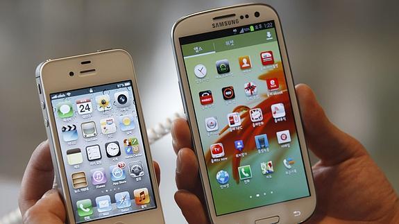 Un hombre sostiene un Iphone 4 y un Samsung Galaxy 