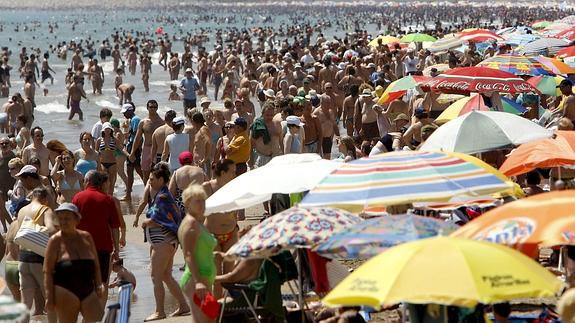 Playa atestada de sombrillas en Valencia. 