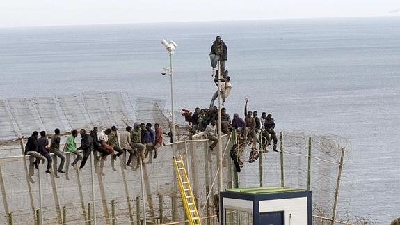 Inmigrantes encaramados a la valla de Melilla. 