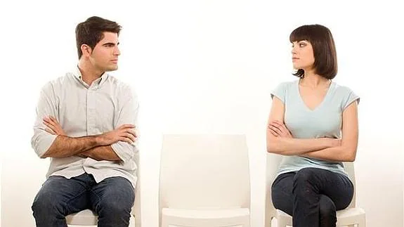 Una pareja se mira con desconfianza tras una discusión. 