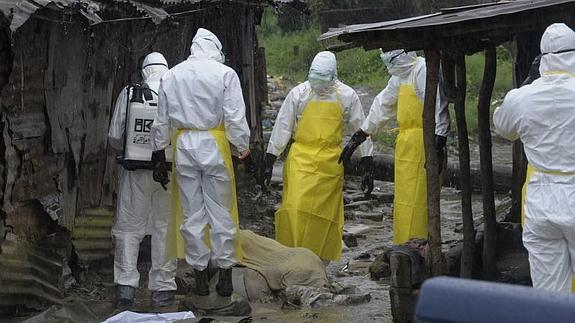 Personal sanitario revisa un cádaver abandonado en Monrovia (Liberia). 