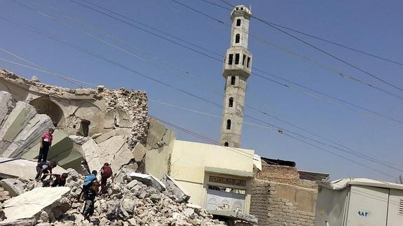 Niños iraquíes caminan entre los escombros del sepulcro del clérigo Sufi en Mosul tras los bombardeos de EE UU. 