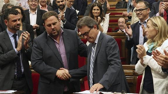 El presidente de la Generalitat, Artur Mas (c), estrecha la mano del lider de ERC, Oriol Junqueras (2i) 