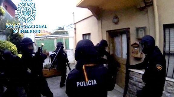 La Policía, en el momento de acceder a la vivienda donde se alojó en Santander. 