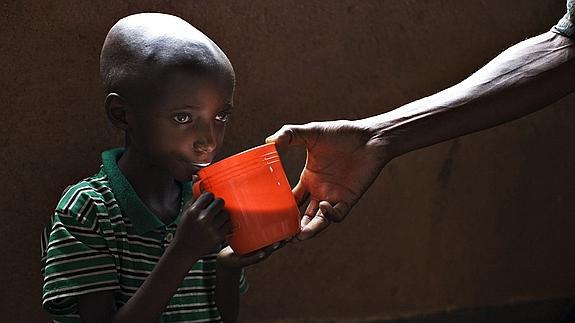 Un niño malnutrido bebe leche en una misión católica del Congo. 