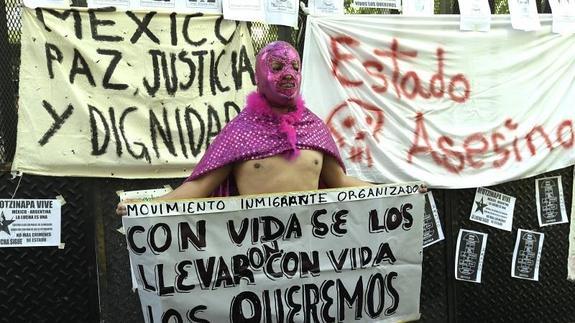 Un hombre disfrazado pide con una pancarta el regreso de los 43 estudiantes secuestrados 