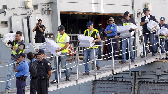 Varios agentes traslandan la droga incautada.