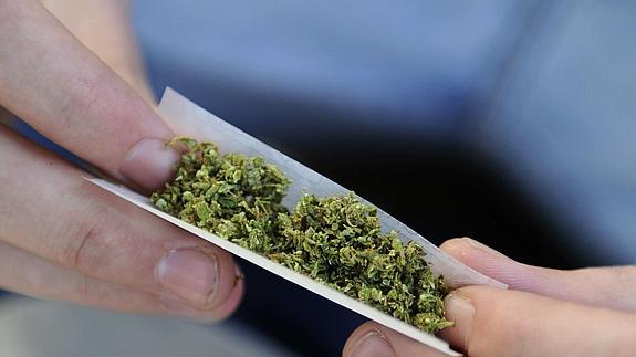 Joven se prepara un "porro" durante una concentración para exigir la legalización del "cannabis"