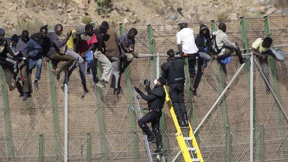 Algunos inmigrantes sobre la valla de Melilla. 