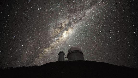 Un telescopio y, de fondo, la Vía Láctea.
