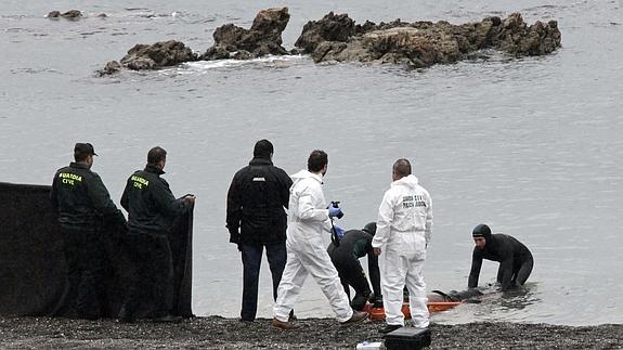 Guardias civiles rescatan un cuerpo de un inmigrante. 