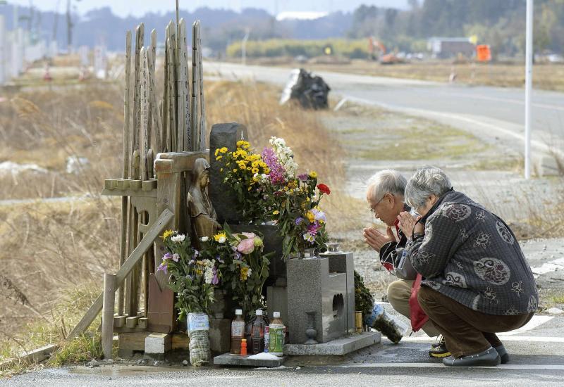 Una pareja reza en uno de los altares en homeanje a las familias fallecidas por el tsunami
