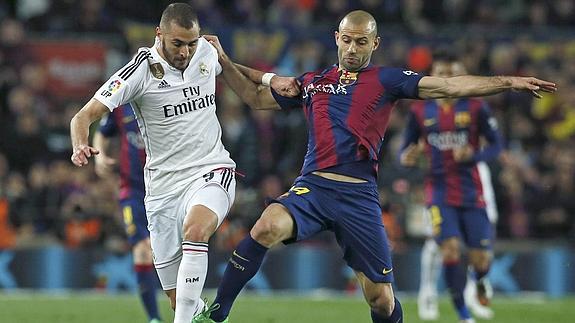 Benzema (d) y Mascherano luchan por la posesión. 