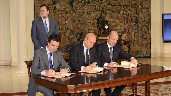 Rajoy y los ministros Soria, Wert y Guindos, en la firma.