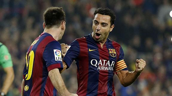 Xavi (d) celebra un gol con Messi. 