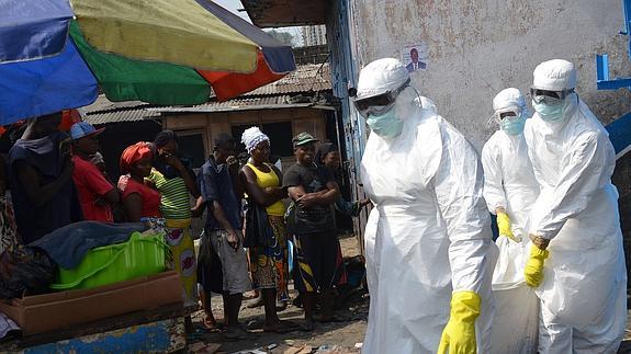 Tres sanitarios retiran un cadáver el pasado enero, durante el brote que sufrió Liberia. Reuters