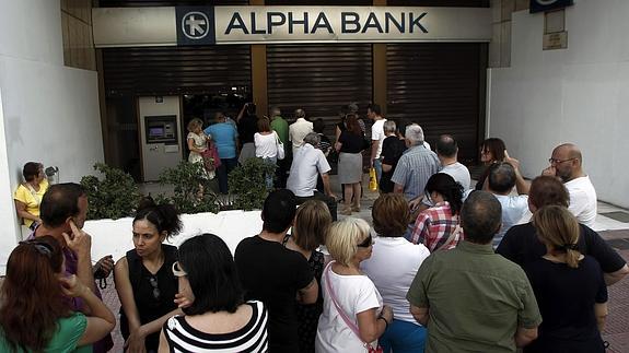 Decenas de personas esperan ante un banco de Atenas.