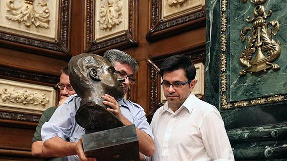 El primer teniente de alcalde del Ayuntemiento de Barcelona, Gerardo Pisarello (d), junto a un operario municipal que retira el busto del Rey Juan Carlos I .