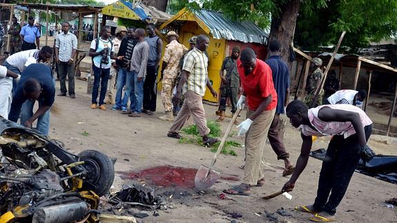 Varias personas recogen los restos tras un atentado de Boko Haram en Maidugur, Nigeria.