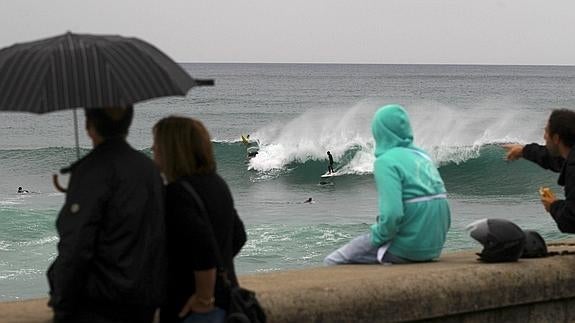 Personas sujetando un paraguas en San Sebastián. 