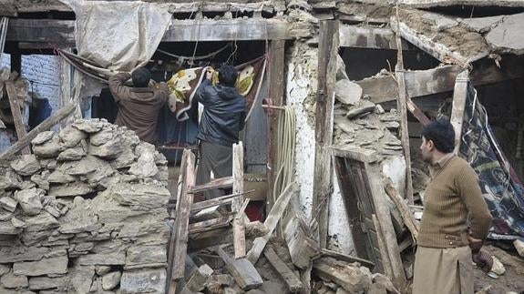 Varias personas inspeccionan una vivienda destrozada en el Valle del Swat en Pakistán.