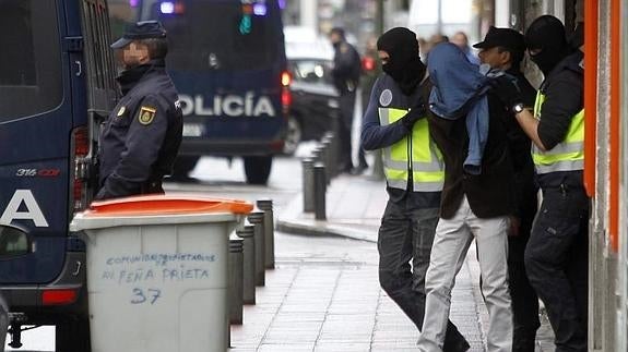 Efectivos de la Policía trasladan al detenido en el barrio de Vallecas. 