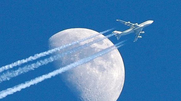 Un avion despegando con la luna de fondo.