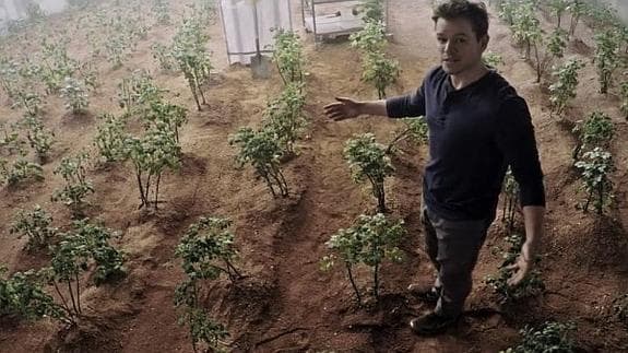 El actor Matt Damon trata de cultivar en el planeta rojo en una escena de la película 'Marte'.