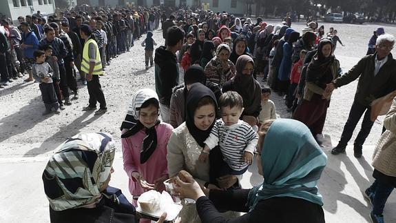 Cientos de refugiados esperan para recibir la comida distribuida por el Ejército griego.