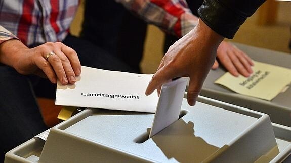 Un votante deposita su papeleta. 