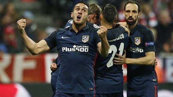 Los jugadores atléticos celebran un gol. 