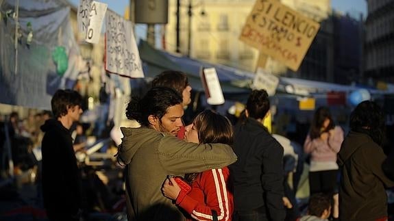 Dos jóvenes se abrazan en Sol durante la acampada del 15M.