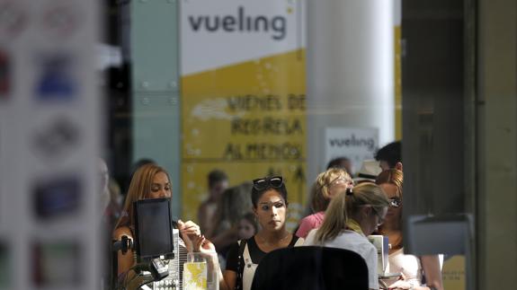 Personal de facturación de Vueling atiende a los viajeros en el Aeropuerto de El Prat. 