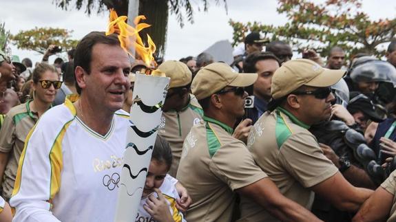 El alcalde de Río porta la antorcha  olimpica entre grandes medidas de seguridad. 