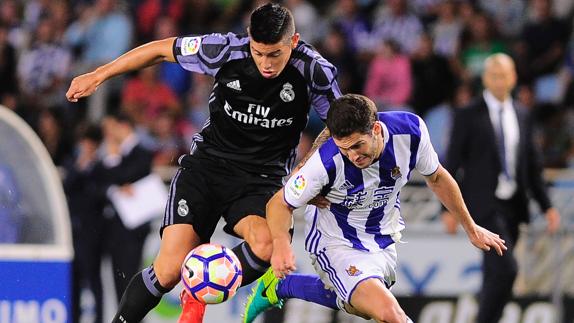 James Rodríguez (izq) disputa un balón contra un jugador de la Real Sociedad. 