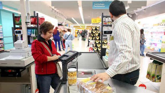 Una mujer realizando la compra en un supermercado. 