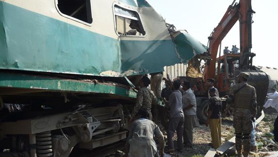 Varias personas buscan supervivientes entre los restos del tren siniestrado.