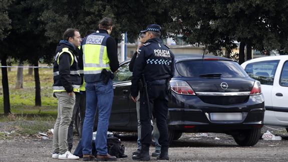 Agentes de la Policía junto al vehículo donde ha sido asesinada la mujer. 