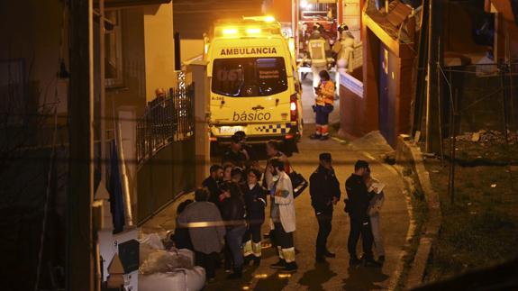 Policía, servicios de emergencia y vecinos, en el exterior de la vivienda, situada en Redondela (Pontevedra).