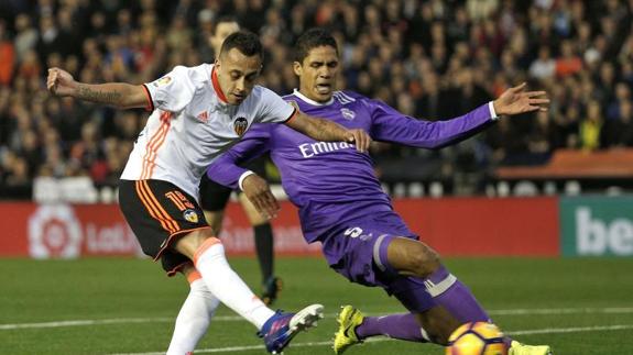 Raphael Varane (d) pelea por un balón con Fabián Orellana en Mestalla. 