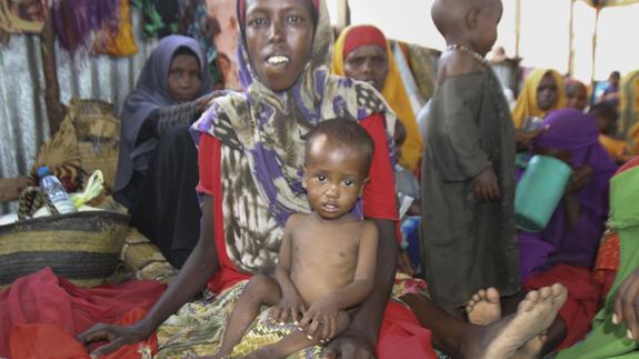 Un niño sentado en el regazo de su madre, en un campo de desplazados en Mogadiscio, Somalia.