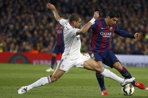 Pepe (i) defiende a Suárez. 
