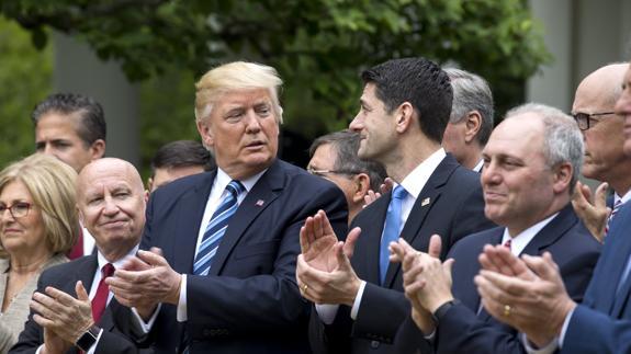 Trump, acompañado por Paul Ryan y otros legisladores, celebra el rechazo al Obamacare.