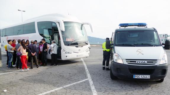 Agentes de la Guardia Civil inmovilizan el autobús que conducía el detenido.