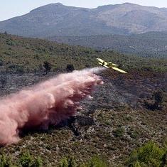Un hidroavión realiza una descarga en la zona del incendio. :: efe